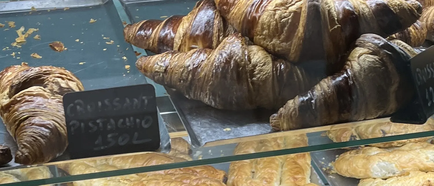 Croissants and spiral byrek on trays in the morning counter
