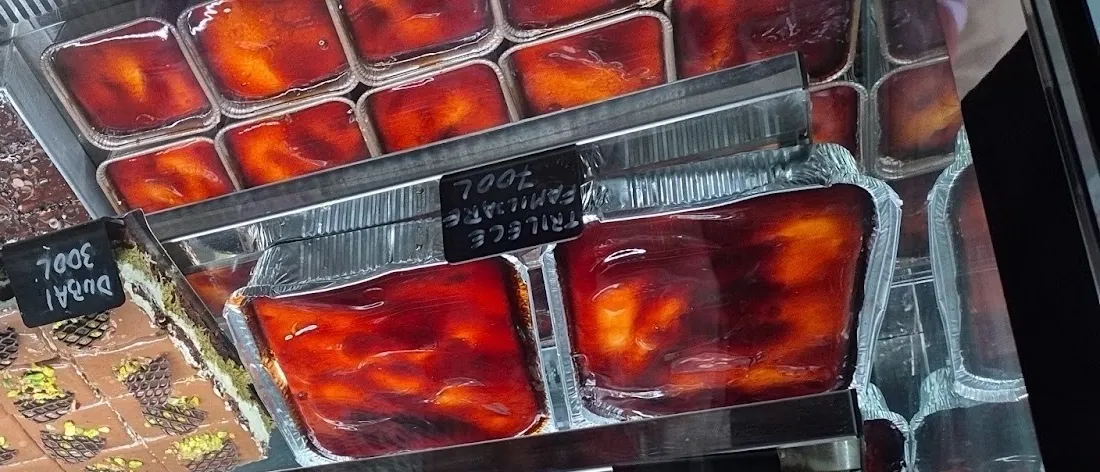Trays of trileçe with a glossy caramel top in the dessert case